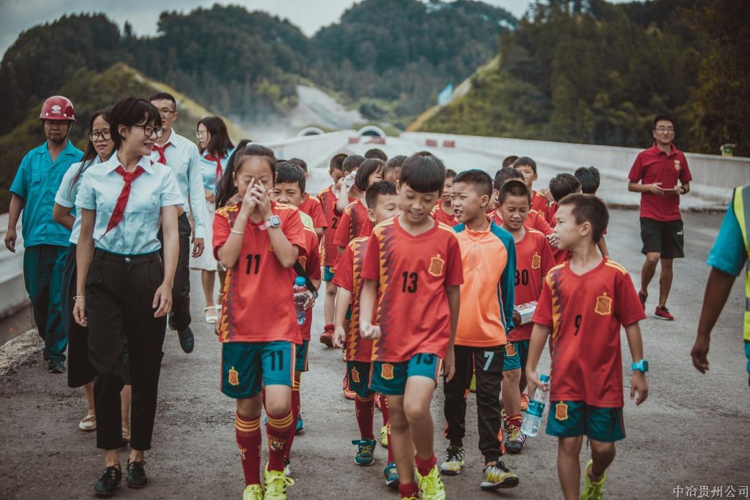 8月18日，由三施項目部定點幫扶的三穗一小足球隊22名小球員們，到三施高速項目進(jìn)行參觀。在施工現(xiàn)場，小朋友們?yōu)榻ㄔO(shè)者們戴上了表達(dá)敬意和謝意的紅領(lǐng)巾。（高凱）